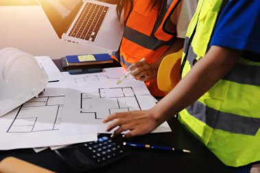 Endüstriyel mühendislerden oluşan bir ekip, fabrikadaki masada bulunan makine planlarını analiz ediyor. Fabrikada ya da üretim tesisinde çalışıyorum..