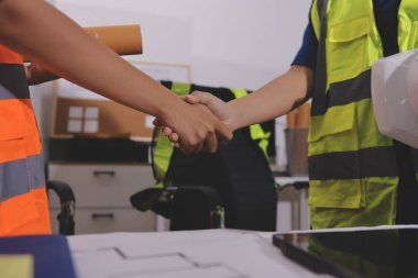 Endüstriyel mühendislerden oluşan bir ekip, fabrikadaki masada bulunan makine planlarını analiz ediyor. Fabrikada ya da üretim tesisinde çalışıyorum..