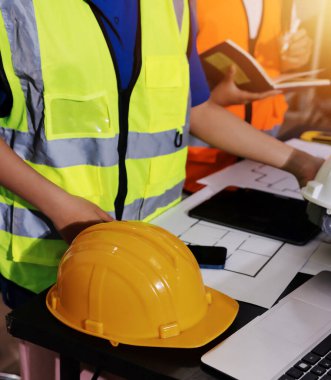 Endüstriyel mühendislerden oluşan bir ekip, fabrikadaki masada bulunan makine planlarını analiz ediyor. Fabrikada ya da üretim tesisinde çalışıyorum..