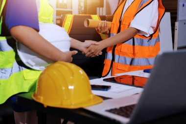 Endüstriyel mühendislerden oluşan bir ekip, fabrikadaki masada bulunan makine planlarını analiz ediyor. Fabrikada ya da üretim tesisinde çalışıyorum..