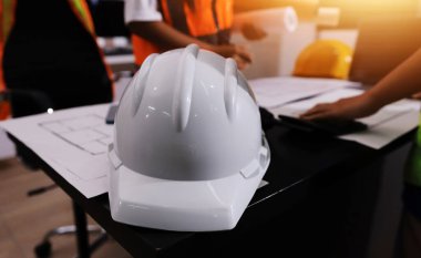 Endüstriyel mühendislerden oluşan bir ekip, fabrikadaki masada bulunan makine planlarını analiz ediyor. Fabrikada ya da üretim tesisinde çalışıyorum..