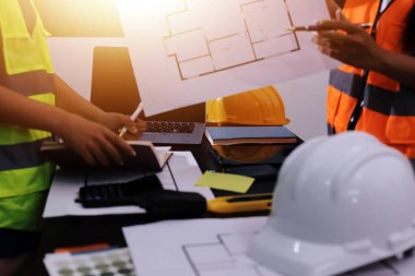 Endüstriyel mühendislerden oluşan bir ekip, fabrikadaki masada bulunan makine planlarını analiz ediyor. Fabrikada ya da üretim tesisinde çalışıyorum..