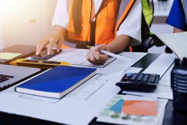 Endüstriyel mühendislerden oluşan bir ekip, fabrikadaki masada bulunan makine planlarını analiz ediyor. Fabrikada ya da üretim tesisinde çalışıyorum..