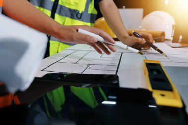 Endüstriyel mühendislerden oluşan bir ekip, fabrikadaki masada bulunan makine planlarını analiz ediyor. Fabrikada ya da üretim tesisinde çalışıyorum..