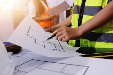 Endüstriyel mühendislerden oluşan bir ekip, fabrikadaki masada bulunan makine planlarını analiz ediyor. Fabrikada ya da üretim tesisinde çalışıyorum..