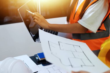 Endüstriyel mühendislerden oluşan bir ekip, fabrikadaki masada bulunan makine planlarını analiz ediyor. Fabrikada ya da üretim tesisinde çalışıyorum..