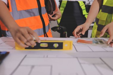 Endüstriyel mühendislerden oluşan bir ekip, fabrikadaki masada bulunan makine planlarını analiz ediyor. Fabrikada ya da üretim tesisinde çalışıyorum..