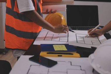 Endüstriyel mühendislerden oluşan bir ekip, fabrikadaki masada bulunan makine planlarını analiz ediyor. Fabrikada ya da üretim tesisinde çalışıyorum..