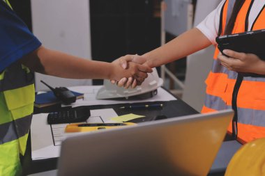 Endüstriyel mühendislerden oluşan bir ekip, fabrikadaki masada bulunan makine planlarını analiz ediyor. Fabrikada ya da üretim tesisinde çalışıyorum..