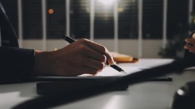 Gece bir defterde yazan iş adamı.