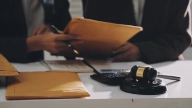 Belgeler ve hesap makinesiyle ofiste çalışan bir iş adamı.