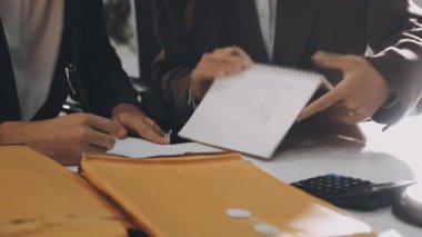 Genç iş adamı ofiste deftere yazı yazıyor.