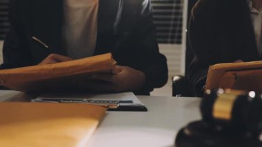 Takım elbiseli genç adam ofiste çalışıyor.