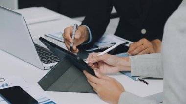 İşadamları yeni planı tartışıyor ve tablet bilgisayarda çalışıyorlar