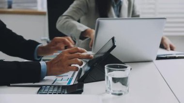 Modern ofisteki ofiste finansal verileri ve grafiği olan dizüstü bilgisayarları kullanarak işadamlarının kapatılması