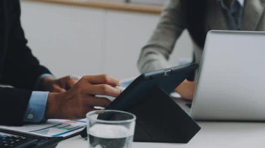 İş adamları modern ofiste dizüstü bilgisayar ve finansal belgelerle birlikte çalışıyorlar. Mali belgeleri olan işadamı.