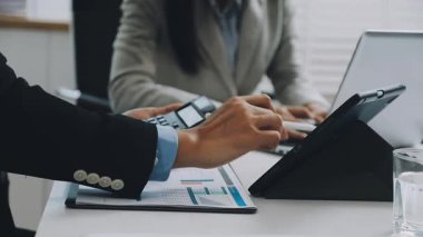 Bir bilgisayardaki finansal verileri hesaplamak için tablet kullanan bir iş adamının eline yakın çekim.