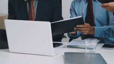 Beyaz gömlekli iki genç iş adamı bir ofiste çalışıyor..