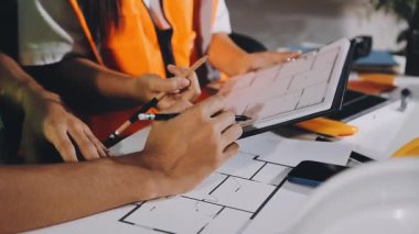 Mimar, evde çalışmak için bir tablet ve plan kullanıyor