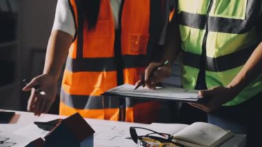 Üniformalı genç bayan işçi ve güvenlik yeleği arka planda inşaat alanı, mühendislik ve mühendislik kavramı ile çalışıyor.