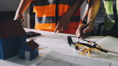 Miğferli kadın mimar ve ofis planları.