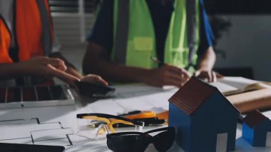 Ofiste planlar üzerinde çalışan inşaat işçisi..