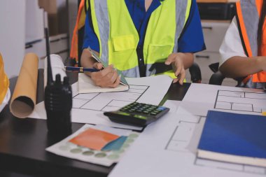 Endüstriyel mühendislerden oluşan bir ekip, fabrikadaki masada bulunan makine planlarını analiz ediyor. Fabrikada ya da üretim tesisinde çalışıyorum..