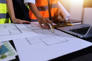 Endüstriyel mühendislerden oluşan bir ekip, fabrikadaki masada bulunan makine planlarını analiz ediyor. Fabrikada ya da üretim tesisinde çalışıyorum..