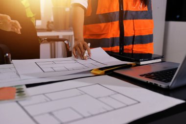 Endüstriyel mühendislerden oluşan bir ekip, fabrikadaki masada bulunan makine planlarını analiz ediyor. Fabrikada ya da üretim tesisinde çalışıyorum..