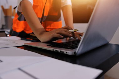 Endüstriyel mühendislerden oluşan bir ekip, fabrikadaki masada bulunan makine planlarını analiz ediyor. Fabrikada ya da üretim tesisinde çalışıyorum..