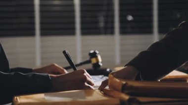 Bir insanın ellerinin kalem tutarak ve masaya notlar yazarak yakınlaşması.