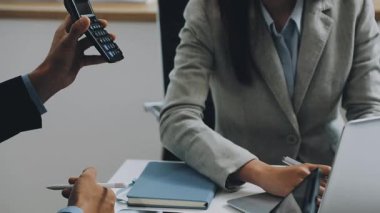 İş ekibi dizüstü bilgisayarda çalışıyor ve mali raporları tartışıyor