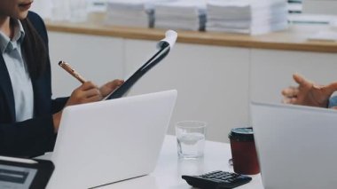 Modern ofiste birlikte çalışan ve laptop kullanan iş adamları.