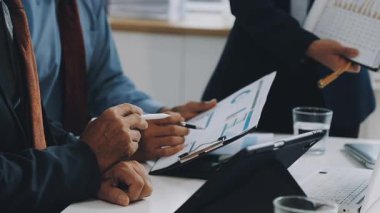 Ofisteki iş adamları dizüstü bilgisayarları, mali raporları ve finansal tabloları masaya yatırdılar..