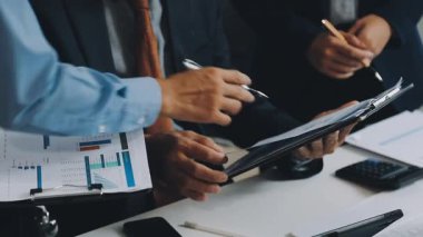 Ofiste belgeleri ve kalemleri olan takım elbiseli işadamı.