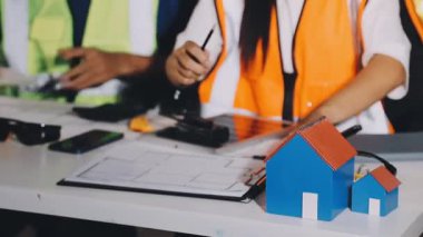 Evin planlarıyla çalışan kadın mühendis ya da mimara yakın plan, seçici odaklanma, bulanık arka plan