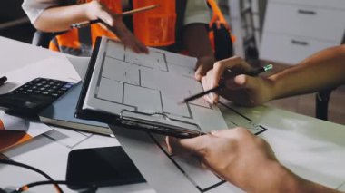 Bina planıyla çalışan mimarın, planla çalışan mimar mühendisinin, planla çalışan ve masa, mühendislik ve inşaat konseptinin üzerine çizim yapan.
