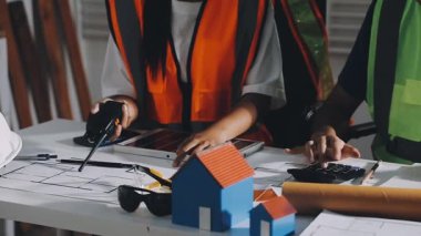 Bir ofisin planlarıyla çalışan bir mimar..