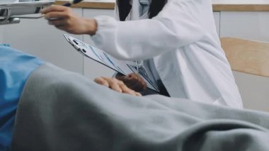 Klinikte çalışırken tablet kullanan üniformalı kadın dişçi