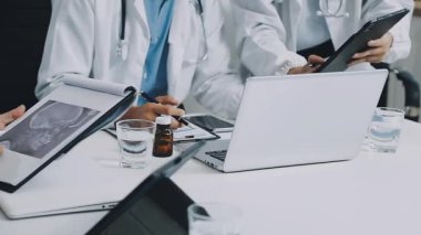 Ofiste dizüstü bilgisayar üzerinde çalışan doktorların yakın çekim görüntüleri..