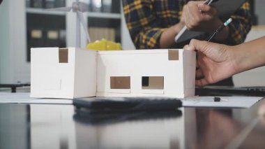 Ofiste model ev modeliyle çalışan genç mimar.