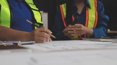 İnşaat şantiyesi veya şantiyesinde inşaat projesi üzerine mühendis, mimar, mühendis ya da işçi çizimi ya da plan.