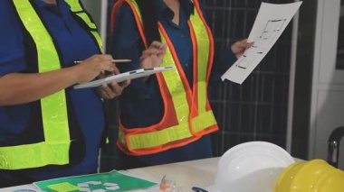 Ofiste çalışan miğferli Asyalı mühendis kadın mühendis planlama, inşaat mühendisi, mühendis veya mühendis fabrikada çalışıyor..