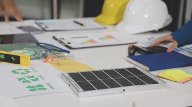 Ofiste güneş panelleriyle tablet üzerinde çalışan mühendis.