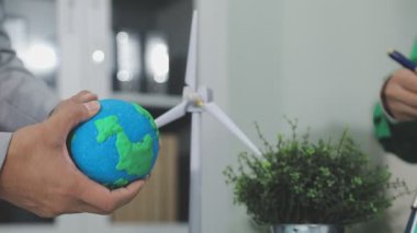 Elinde bir gezegeni gösteren bir iş adamının yakın görüntüsü.