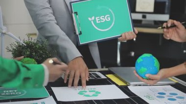 Elinde imzası olan yeşil takım elbiseli bir işadamı.