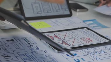 Tasarımcı ofisinde cep telefonuyla çalışıyor