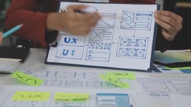 Tasarımcı ekranda skeçle birlikte dizüstü bilgisayarda çalışıyor