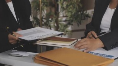 Yakın çekim. İş kadını masadaki ortağıyla el sıkışıyor.