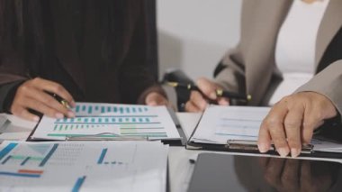 İş adamları iş yerlerinde mali tabloları ve grafikleri tartışıyor